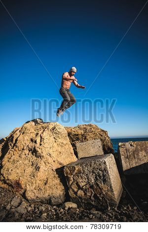 man performs freerunning jump on stones