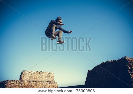 man performs freerunning jump on stones