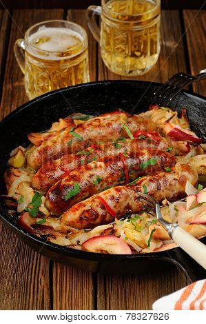 Sausages Fried In Cast Iron Skillet With Two Beer Mugs