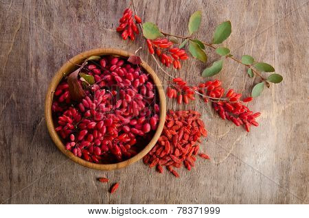 Barberry With Leaves And Dry Goji Berries On Wooden Background