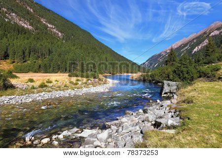 Headwaters of waterfalls - the narrow fast  river among green mountain meadows. National Park Krimml Waterfalls in Austria