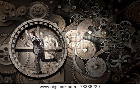 Young businessman in suit running in hamster wheel