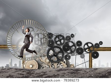 Young businessman in suit running in hamster wheel