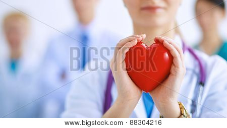 Female doctor with stethoscope holding heart .