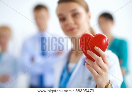 Female doctor with stethoscope holding heart .