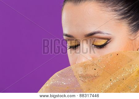 Girl with a professional makeup posing on a purple background.