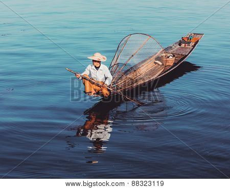 Myanmar travel attraction - Traditional Burmese fisherman at Inle lake, Myanmar famous for their distinctive one legged rowing style. Vintage filtered retro effect hipster style image