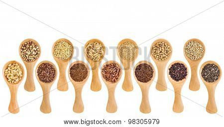 a variety of gluten free grains (buckwheat, amaranth, brown rice, millet, sorghum, teff, black, white and black quinoa, chia seeds, flax seeds) on wooden spoons isolated on white