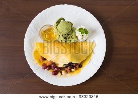 Pancake and fruit with ice cream on table