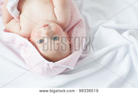 cute baby under a blanket in bed