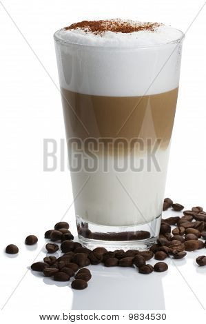 Latte macchiato s kávová zrna na bílém pozadí