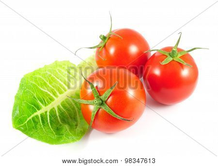 Fresh tomatoes with salad leaf isolated on white