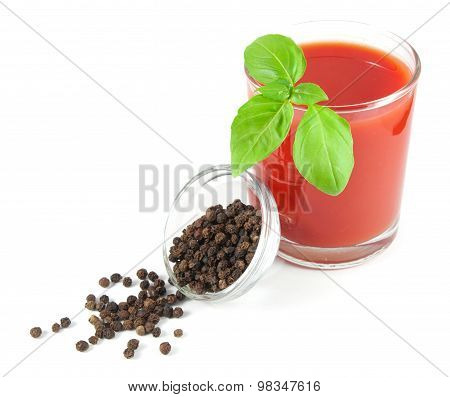 Glass of tomato juice with basil leaves and bowl with black pepper isolated on white