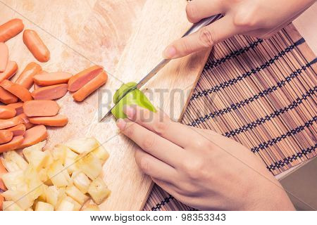 Preparing sausage and vegetables woman hands vintage tone.