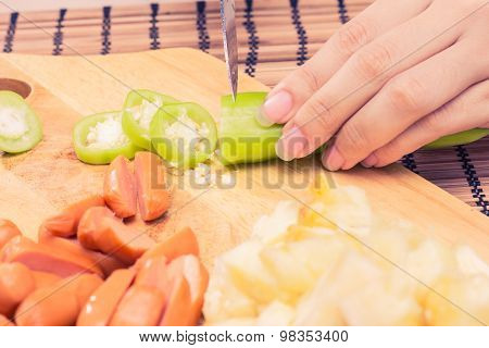 Preparing sausage and vegetables woman hands vintage tone.