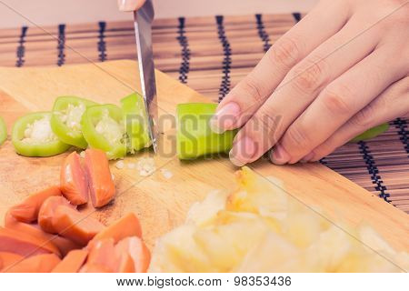 Preparing sausage and vegetables woman hands vintage tone.