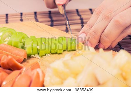 Preparing sausage and vegetables woman hands vintage tone.