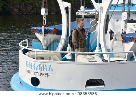 VALAAM ISLAND, RUSSIA - JULY 29, 2015: Vyacheslav Alekseev on the ship keeps cages with Ladoga ringed seals. Animals were cured and released into the Ladoga lake
