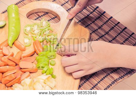 Preparing sausage and vegetables woman hands vintage tone.