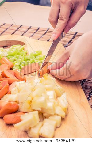 Preparing sausage and vegetables woman hands vintage tone.