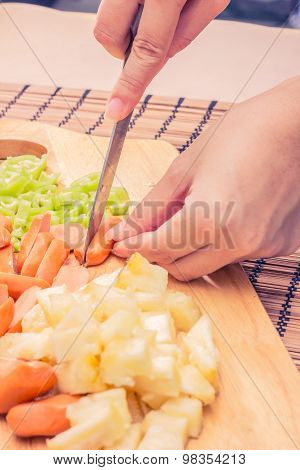 Preparing sausage and vegetables woman hands vintage tone.