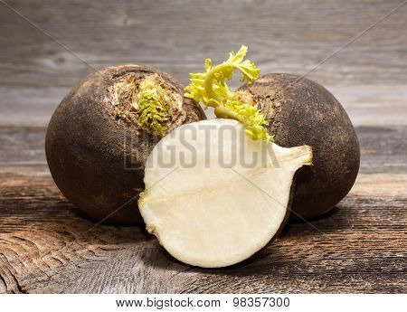 Black radish on wooden background