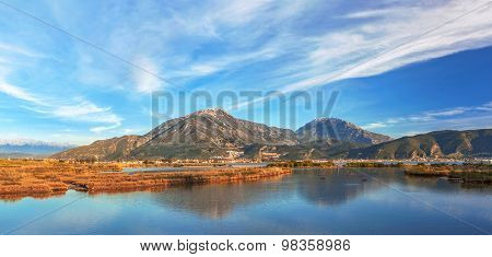 Lake overgrown with reeds mountains in background