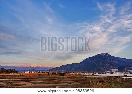 Lake overgrown with reeds mountains in background