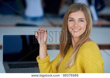 portrait of happy smilling student girl at tech classroom with laptop computer in background