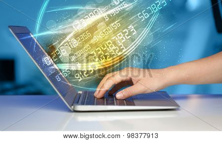 Man typing on modern notebook with future number technology data coming out