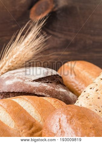 Close up view of differnet bread on brown wooden background. Copy space. Shallow DOF. Vertical.