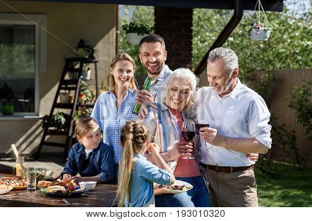 Portrait Of Smiling Multi-generational Family Having Picnic On Patio At Daytime