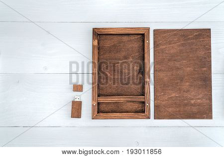 Empty wooden box for gift or photo with usb stick free space. Packaging for photo and USB drives on white wooden background. Information and mail concept