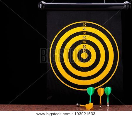 Magnetic dart arrows on granite surface and yellow dart board background.