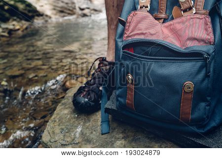 Adventure Hiker Man Feet Backback And Thermos On Waterfall Background Closeup Journey Hiking Travel Concept