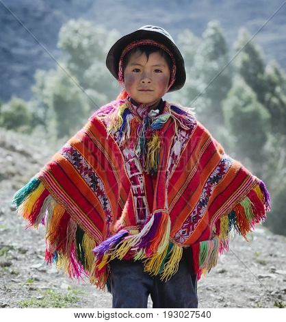 Peruvian boy dressed in colourful traditional handmade outfit. October 21 2012 - Patachancha, Cuzco, Peru