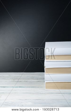 Open black and Whitel books on wooden table, black board background. Back to school. Education business concept