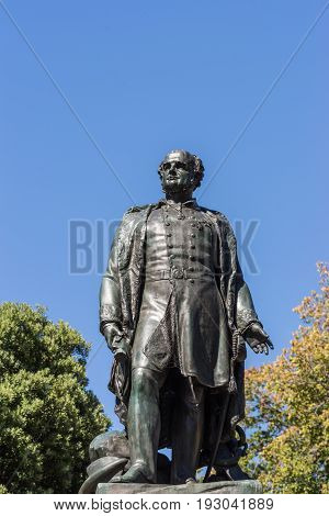 Hobart Australia - March 19. 2017: Tasmania. Closeup of bronze statue of Rear Admiral Sir John Franklin shows him looking proudly. Green park background with fountain and blue sky.