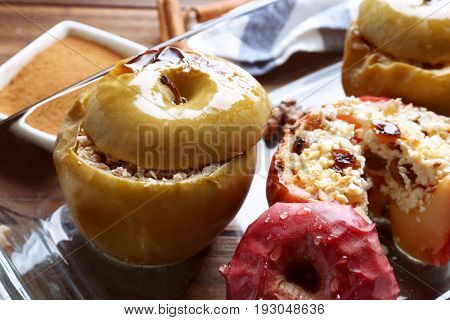 Glass dish with tasty baked apples on table, closeup