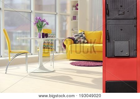 Energy savings concept. Solid fuel boiler in living room 