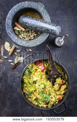 Indian Vegetable Biryani with Sweet Pepers and Zucchini as close-up in a frying pan