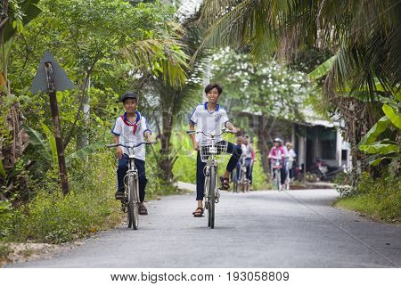 An Binh Island, Vietnam - March 25, 2017 : Vietnamese pioneers go home from school by bicycles on An Binh island, Vinh Long, Vietnam