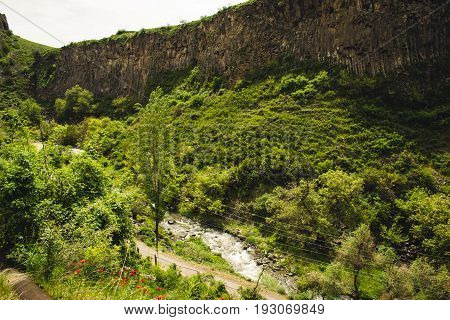 Mountain unique geological formation called Symphony Stones. Basalt rock. Ecotourism. Nature background. Adventure holiday. Armenia, Garni gorge with river. Travel vacation. Climbing tourism concept.
