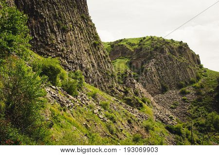 Mountain landscape with unique geological formation. Basalt rock. Ecotourism. Nature background. Adventure holiday. Armenia, Garni. Travel vacation. Climbing tourism and hiking concept. Beauty world