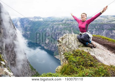 Happy people relax in cliff during trip Norway. Kjerag hiking route.