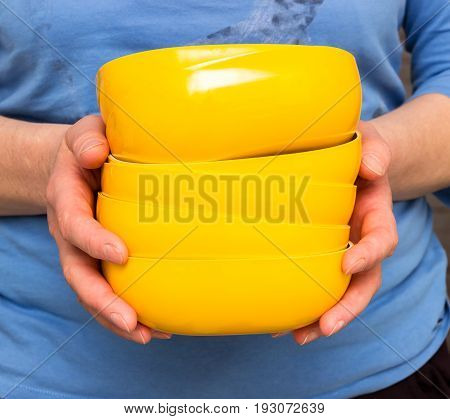 woman holding yellow plates in a kitchen