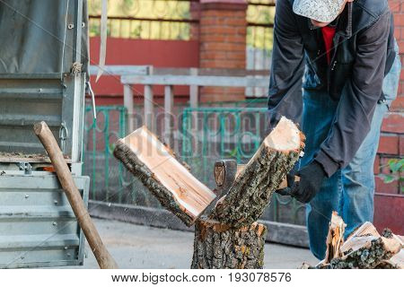 Splits Firewood The Axe. The Man Splits The Axe Wood.