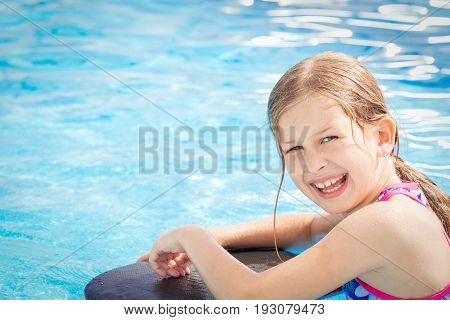 Girl with long hair enjoying the swimming pool in the Summer