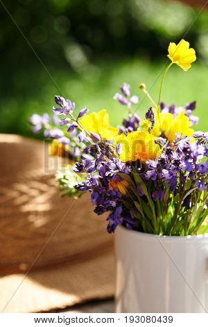 wild flowers and summer srtaw hat at sunny day