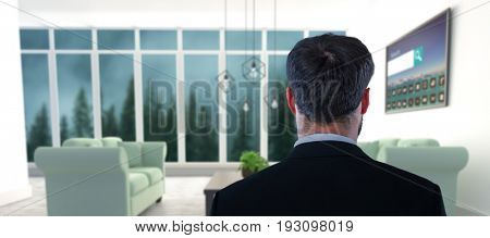 Businessman pretending to standing against invisible screen against blue sofas on floor in modern living room